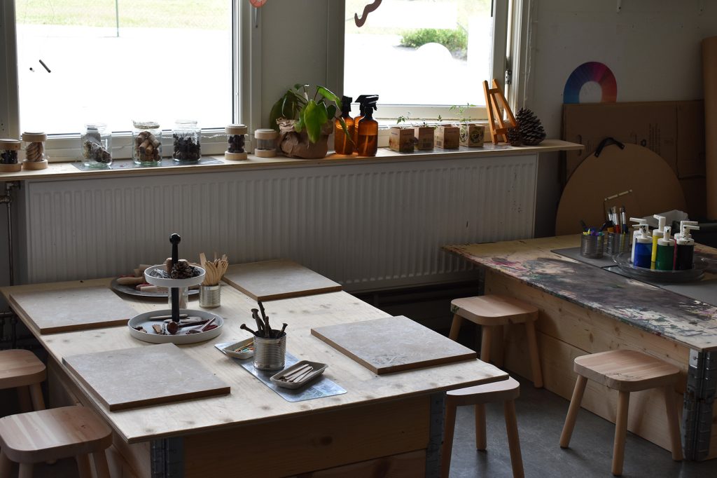 Pysselstationer med färg, naturmaterial och kritor på Hästhagens förskola